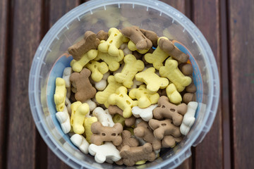 Animal goodies in small plastic bucket on wooden table