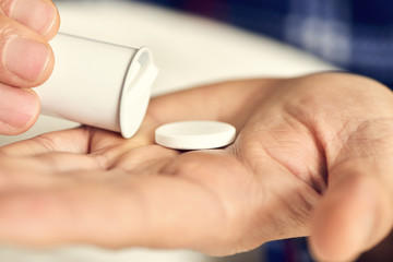 man in bed about to take a tablet
