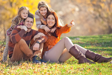 Happy family are joying on the autumn nature