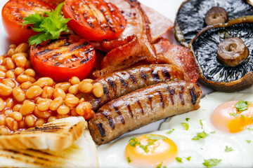 Full English breakfast with bacon, sausage, egg, beans and mushrooms