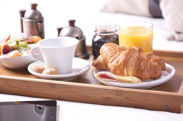 Tray with breakfast on a bed in a hotel room