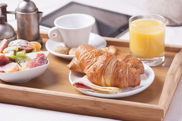 Tray with breakfast on a bed in a hotel room
