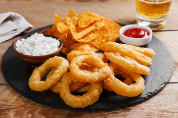 fried onion rings in batter with sauce tortilla chips