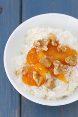 fresh cheese with pumpkin jam and nuts in bowl on blue wooden background