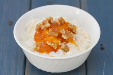fresh cheese with pumpkin jam and nuts in bowl on blue background
