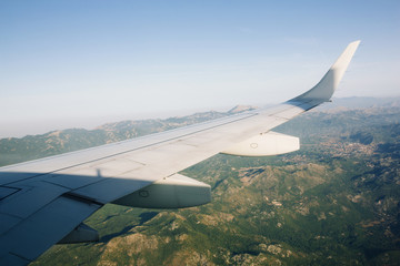 Airplane flying above green mountains