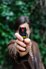 Frau hält drohend Pfefferspray in die Kamera