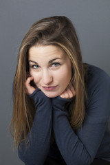 boredom concept - smiling beautiful female teenager looking bored or tired with face leaning on her...