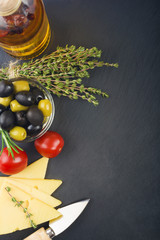 cheese with fresh herbs, black and green olives, cherry tomatoes, selective focus