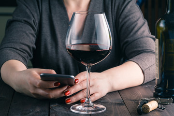 woman enjoying a glass of wine in her kitchen