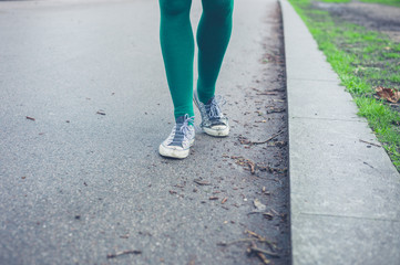 Legs of young woman walking outside