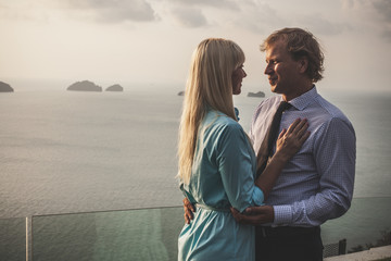 Beautiful embracing couple dressed in formal wear on the tropica