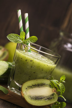 Glass of green refreshing smoothie with kiwi, cucumber and apple. Toned image. Selective focus