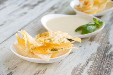Delicate hummus with chips on a white plate