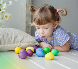 Fototapeta na wymiar Little girl with colorful eggs close-up