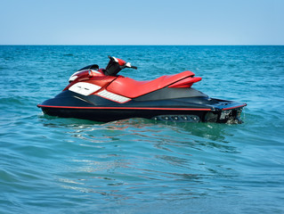 Jet-ski on waves of the sea against the blue sky