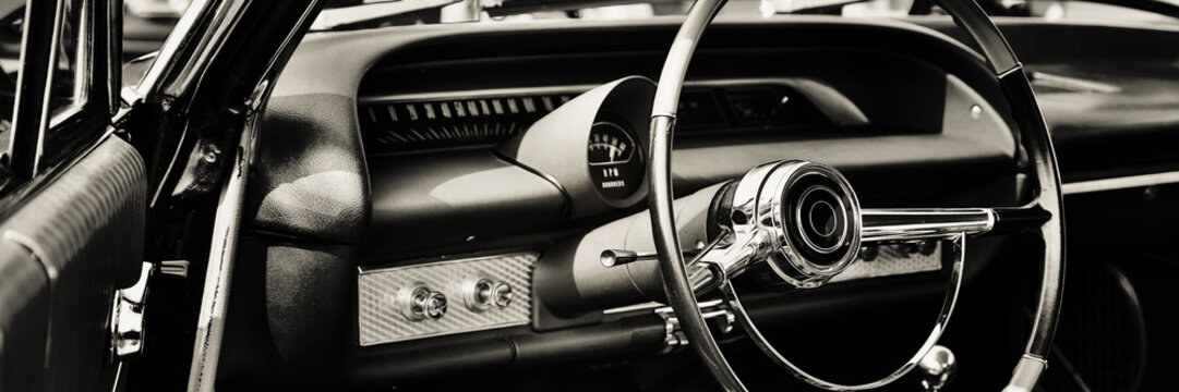 interior of classic car with close up on dashboard with steering wheel. 
