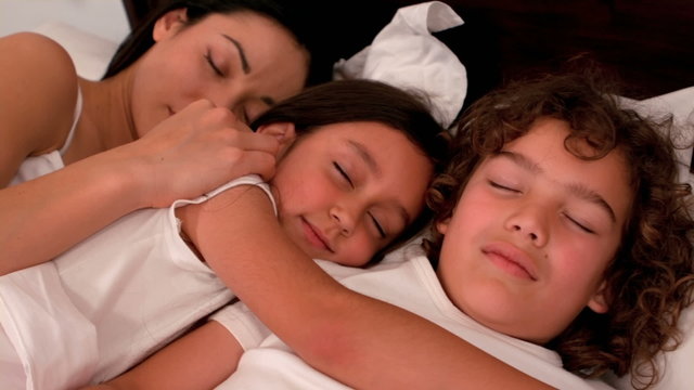 Happy family sleeping in bed