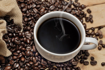 Hot coffee / Hot coffee and coffee beans placed on a wooden floor. Top view.