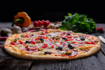 Freshly baked pizza with feta cheese, olives, salami and paprika