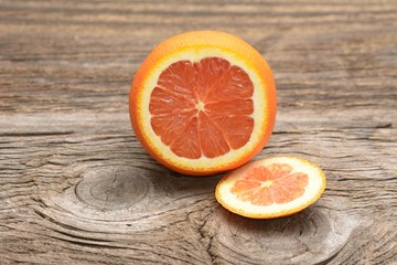 Grapefruit with slices on a wooden table.