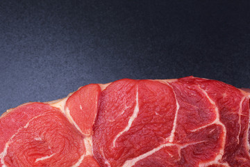 one piece of raw beef meat  on black background