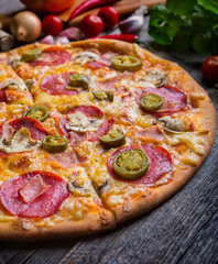 Pepperoni pizza with ham and jalapeno chili peppers