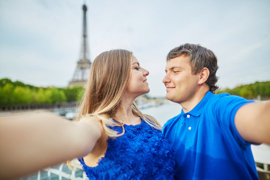 Beautiful young dating couple in Paris making selfie