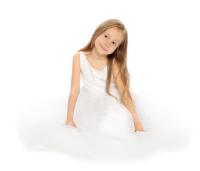 Fototapeta na wymiar Pretty little girl in a delicate white dress sitting on floor - Isolated on white background