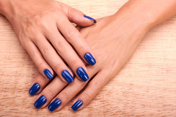 Obraz na płótnie Canvas Woman hands with blue manicure and nail polish