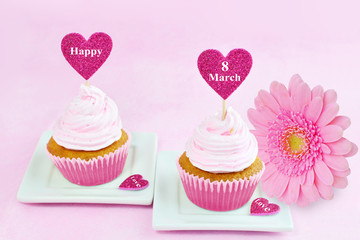 8 March Women's Day pink greeting card with cupcake, heart and gerbera daisy.