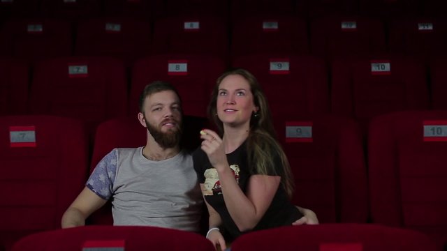 Boy and girl making fun in the cinema.