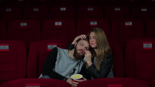 Guy with a girl crying in the cinema.