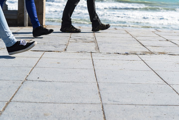Active people walking on sidewalk on sunny day in spring