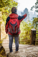 Young female tourist pointing at scenic mountains