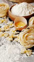 Uncooked pasta with flour on the table, selective focus