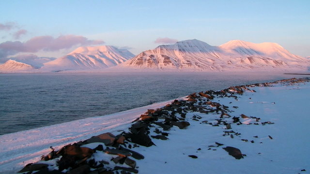 View to the arctic sea shore and mountains at Spitsbergen (Svalbard) archipelago at sunset in spring near Longyearbyen, Norway.