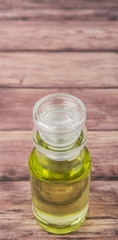 Grape seed oil in glass vial over wooden background