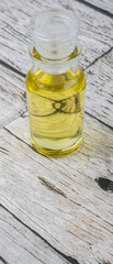 Sesame seed oil in glass vial over wooden background