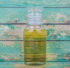 Sesame seed oil in glass vial over wooden background