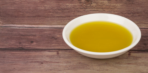 Fototapeta na wymiar Avocado oil in white bowl over wooden background