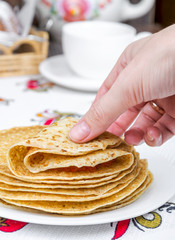 Takes hand and turns a pancake with red caviar