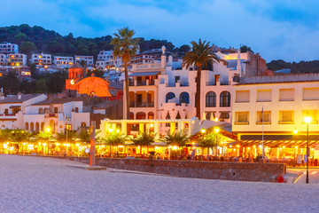 Night beach and promenade with cafes and restaurants in Tossa de Mar on the Costa Brava, Catalunya, Spain