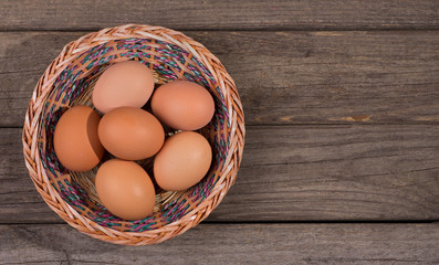 Basket of Brown Eggs on a Rustic Wooden Background