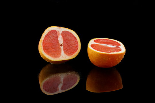eine geteilte grapefruit auf schwarzen hintergrund