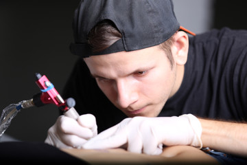 Tattooist makes tattoo, close up