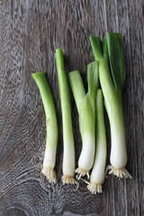 Green onions with roots on a wooden background 