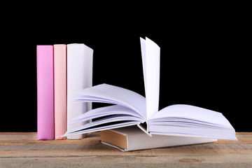 Stack of books on wooden table,  black background