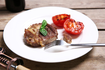 Roasted beef fillet on plate, on wooden background