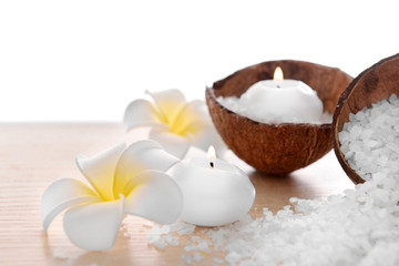 Spa concept of plumeria, coconut and candles with sea salt, isolated on white